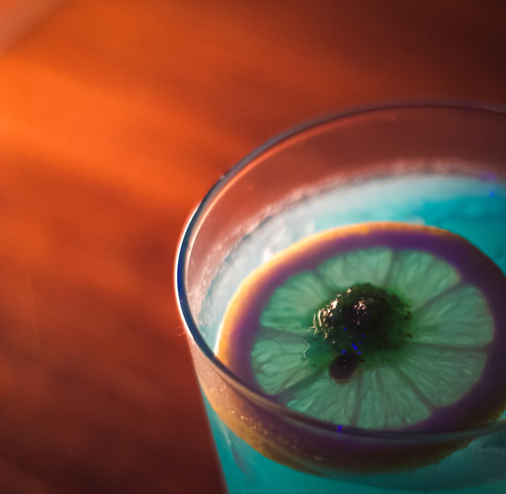 A vibrant blue cocktail with a lime slice garnish at the Craft Cocktail Play It Cool Pop-Up Bar Event.