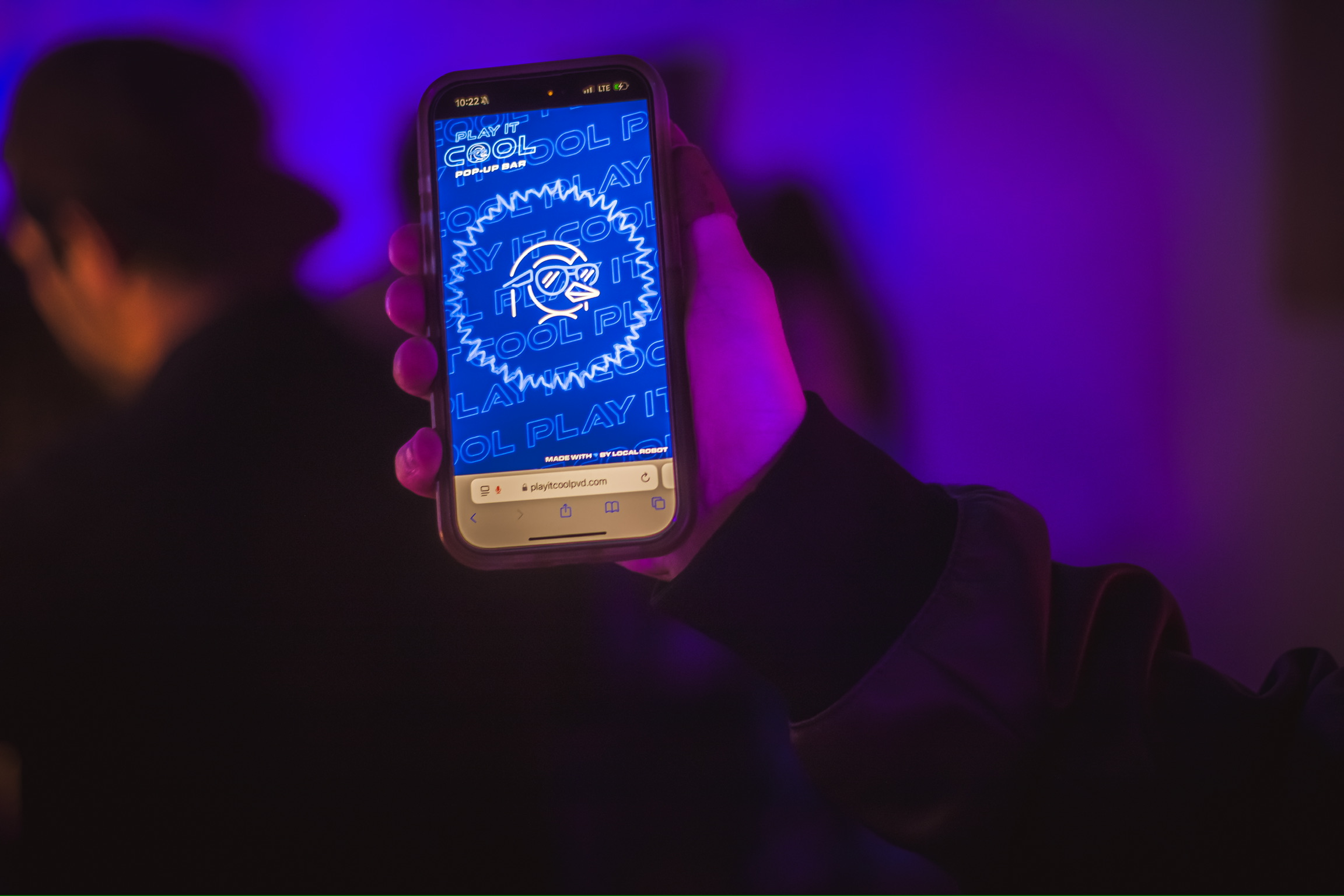 Play It Cool Interactive Audio Visualizer displayed on a smartphone screen, held in a dimly lit, purple-toned environment.