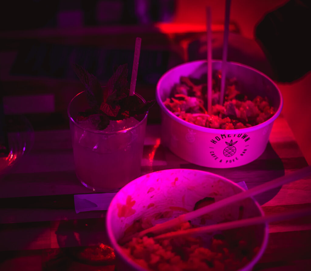 Craft cocktail and poke bowls at the "Craft Cocktail Play It Cool Pop-Up Bar Event" under vibrant red lighting.